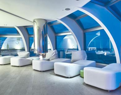Luxurious lounge with white furniture and large panoramic windows.