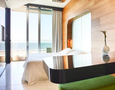 Modernes Zimmer mit Meerblick, elegante Möbel und große Fenster.