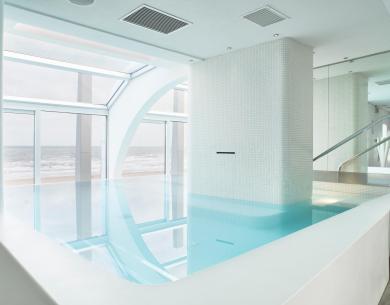 Piscine intérieure avec vue sur l'océan et design moderne et lumineux.