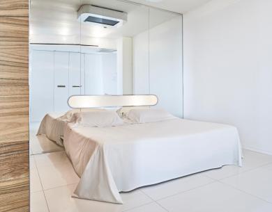 Modern room with a double bed and mirrors.
