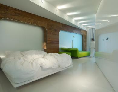Chambre moderne avec lit blanc et canapé vert.