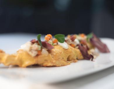 Piatto gourmet con ingredienti freschi e colorati su un piatto bianco.
