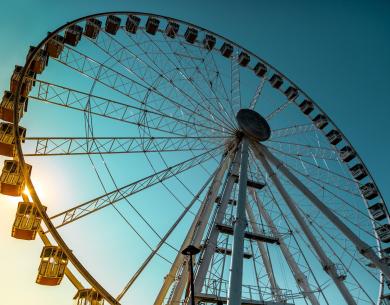 Grande roue au coucher du soleil, ciel bleu, ambiance de merveille et sérénité.