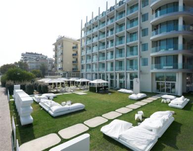 Modern hotel with garden and outdoor relaxation area.