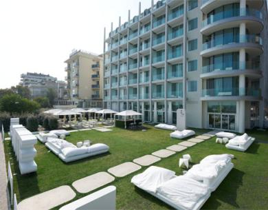 Hotel moderno con giardino e arredamento bianco.
