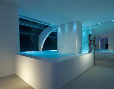 Piscina interna con luci soffuse e design moderno.