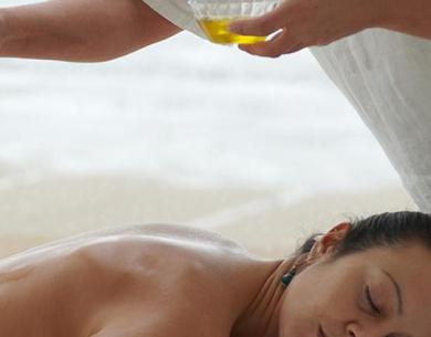 Relaxing oil massage on a beach.