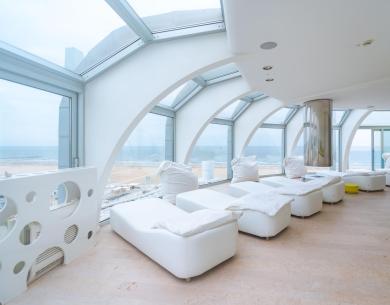 Relaxation room with sea view and white loungers.