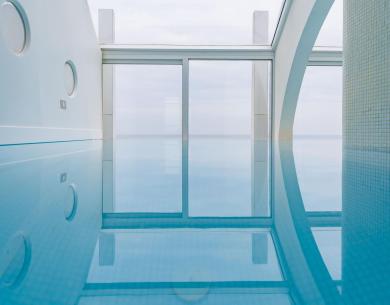 Modern indoor pool with large windows and natural light.