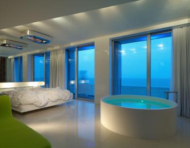Modern room with tub, sea view, and soft lighting.