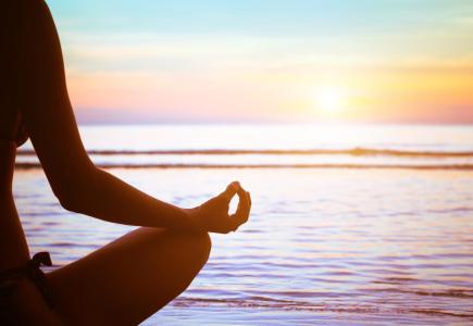 Méditation au coucher du soleil en bord de mer, paix et sérénité.