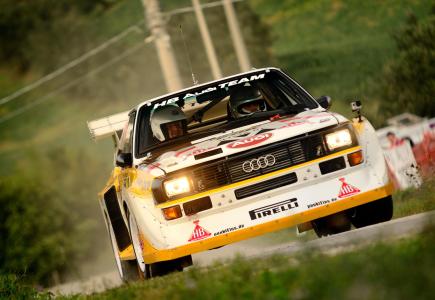 Auto da rally Audi in azione su una strada sterrata.