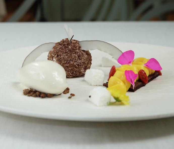 Dessert elegante con cocco, mango e petali di fiori.