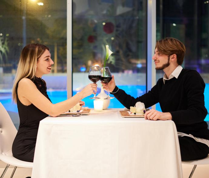 Coppia brinda a cena romantica in ristorante elegante.