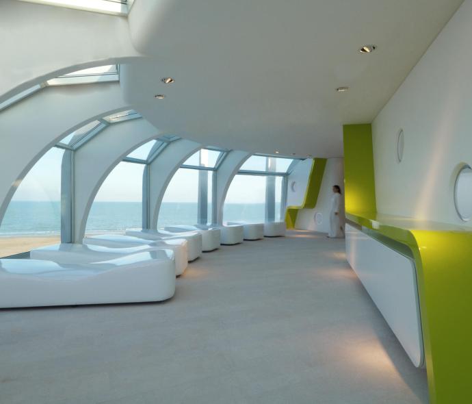 Moderne Zimmer mit Meerblick, weiße Möbel und grüne Wände.