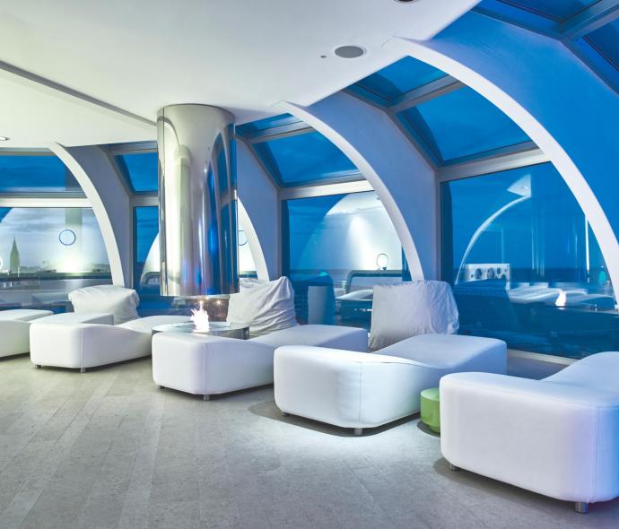 Luxurious lounge with white furniture and large panoramic windows.