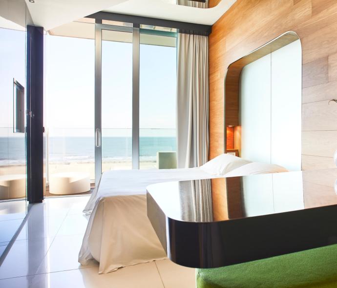 Modernes Zimmer mit Meerblick, elegante Möbel und große Fenster.