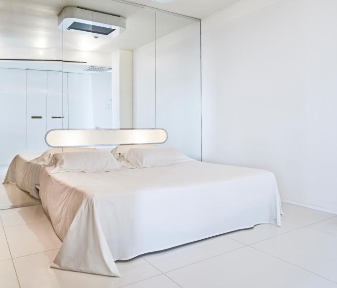 Modern room with a double bed and mirrors.