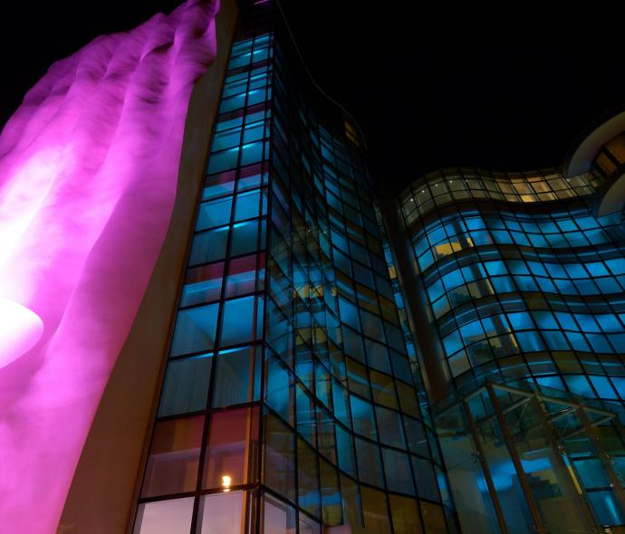 Edificio moderno con luci colorate e design ondulato.