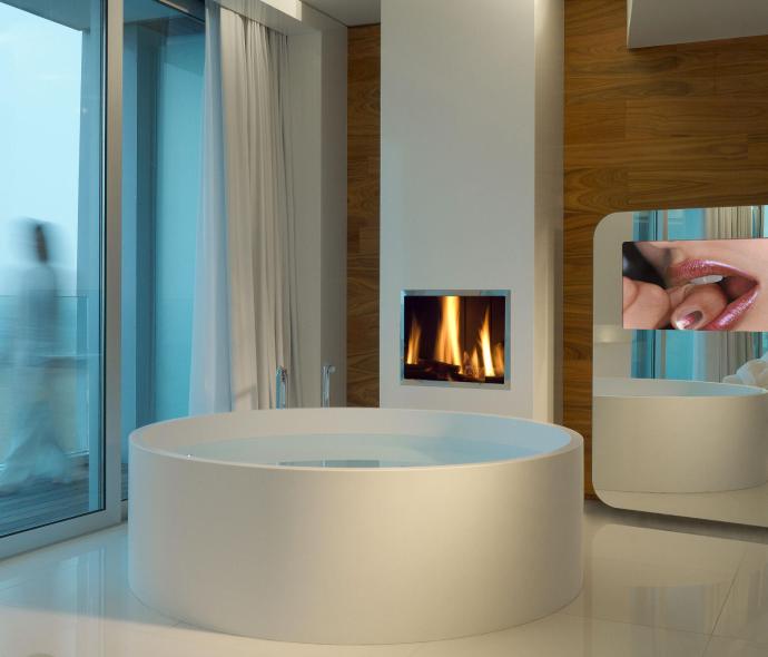 Salle de bain moderne avec baignoire, cheminée et miroir.