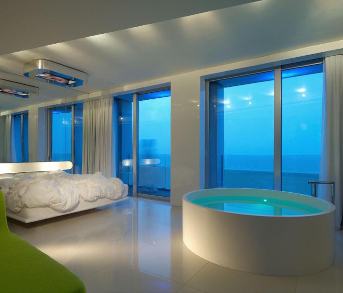 Chambre moderne avec baignoire et vue sur la mer.