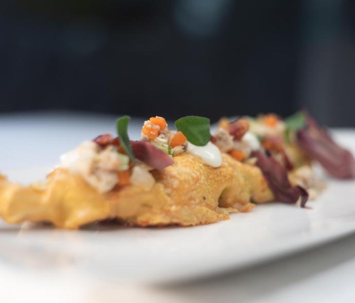 Piatto gourmet con ingredienti freschi e colorati su un piatto bianco.