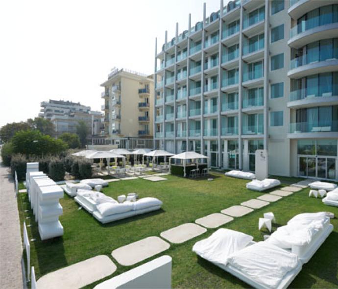 Modern hotel with garden and outdoor relaxation area.