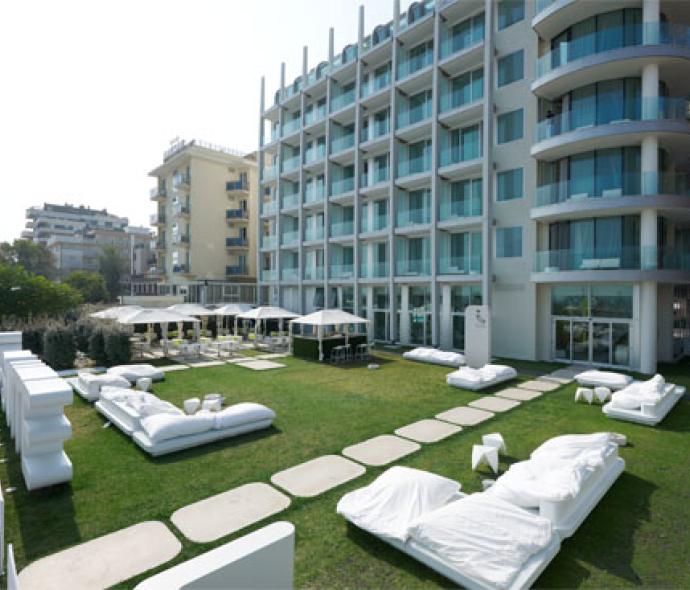 Hotel moderno con giardino e arredamento bianco.