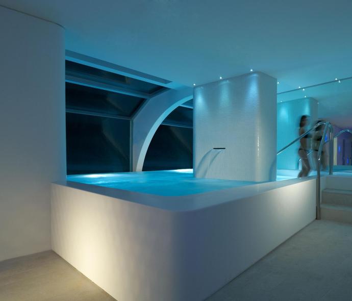 Piscina interna con luci soffuse e design moderno.