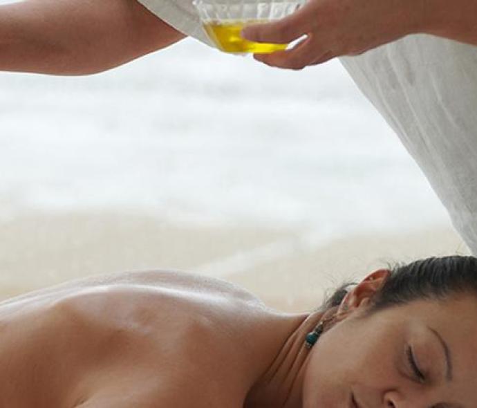 Relaxing oil massage on a beach.