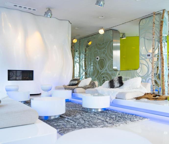 Modern living room with white sofas and futuristic decor.