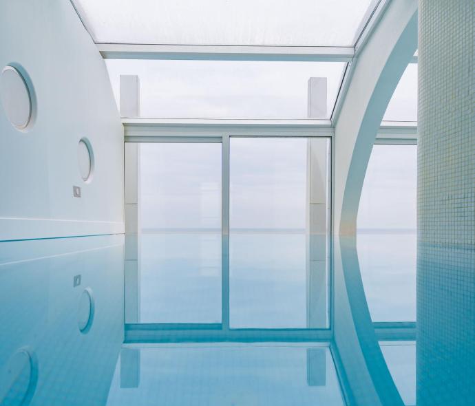 Modern indoor pool with large windows and natural light.