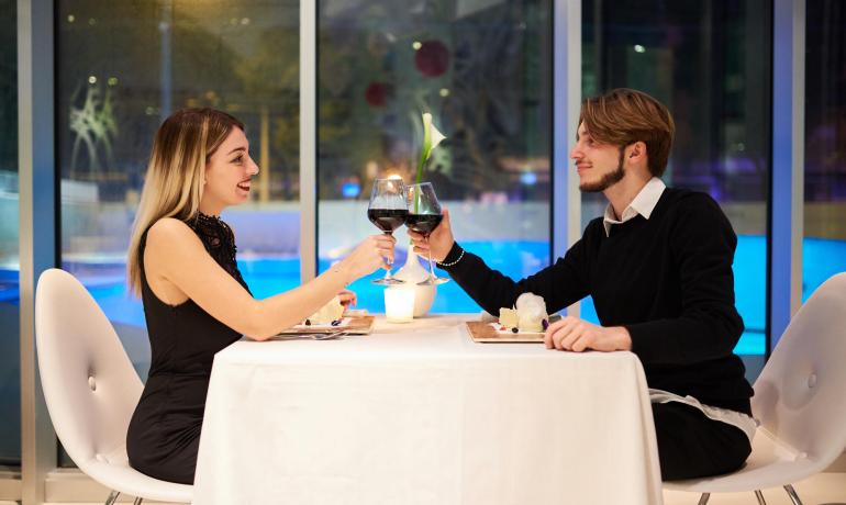Coppia brinda a cena romantica in ristorante elegante.