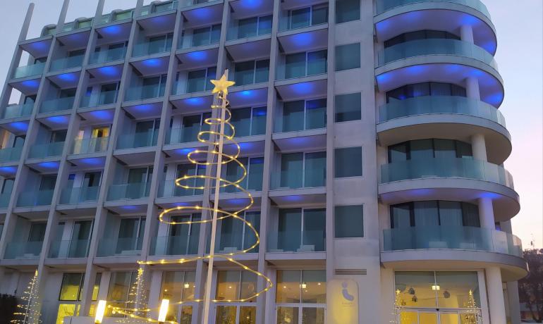 Edificio moderno con luci blu e decorazioni natalizie.