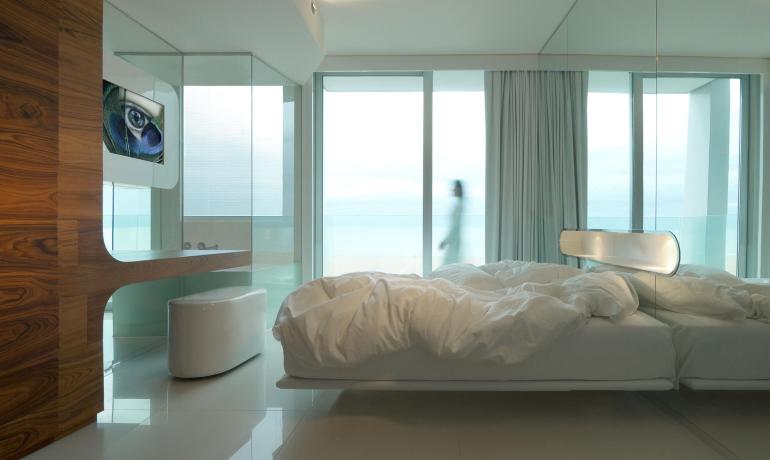 Modern room with floating bed and sea view.