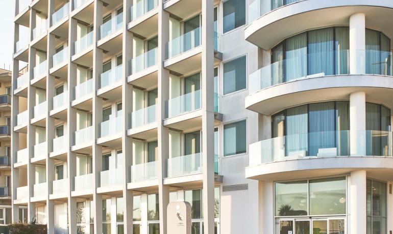 Modern residential building with balconies and a well-maintained garden.