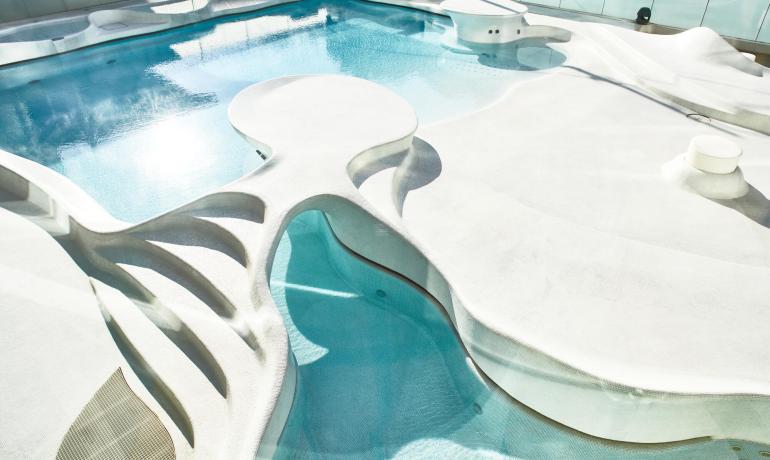Piscine moderne avec design organique et courbes fluides.