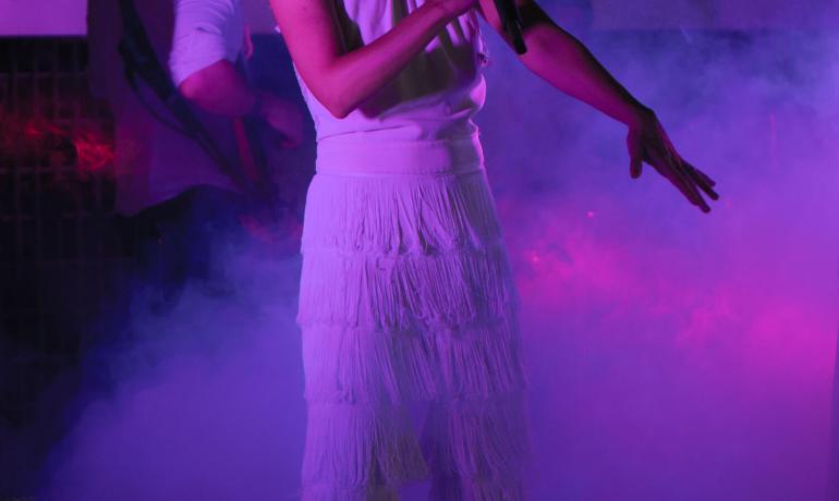 Passionate singer performing with purple lights and smoke.