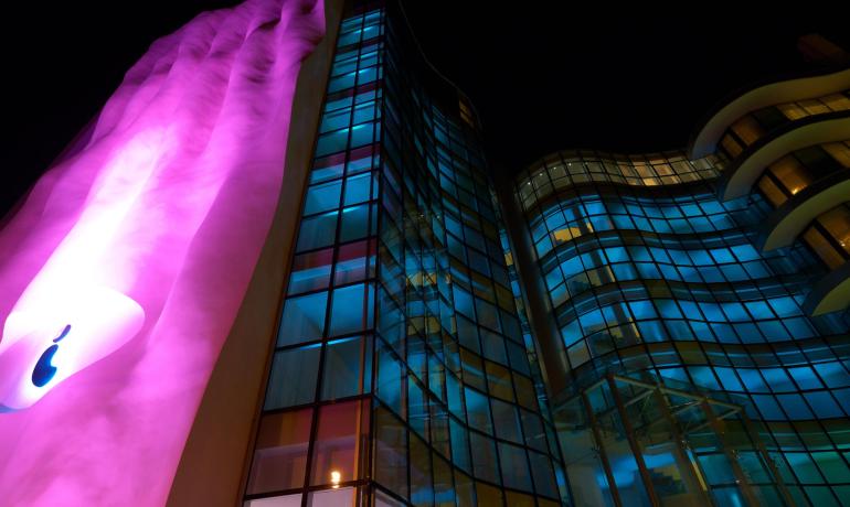 Edificio moderno con luci colorate e design ondulato.