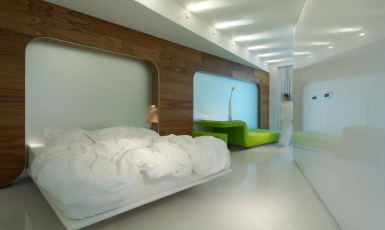 Camera moderna con letto bianco e divano verde.