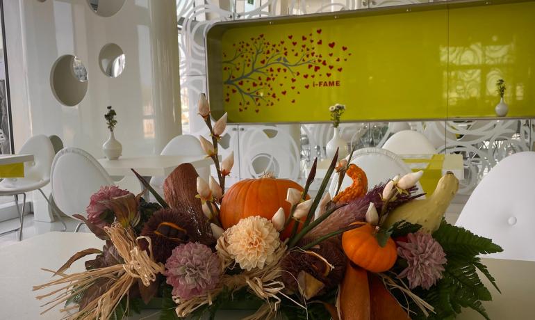 Decorazione autunnale con zucche e fiori in un ristorante moderno.