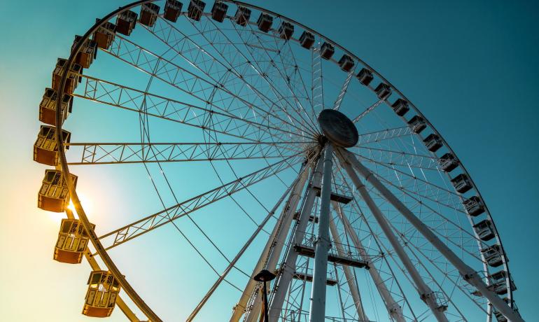Ferris wheel at sunset, blue sky, atmosphere of wonder and serenity.
