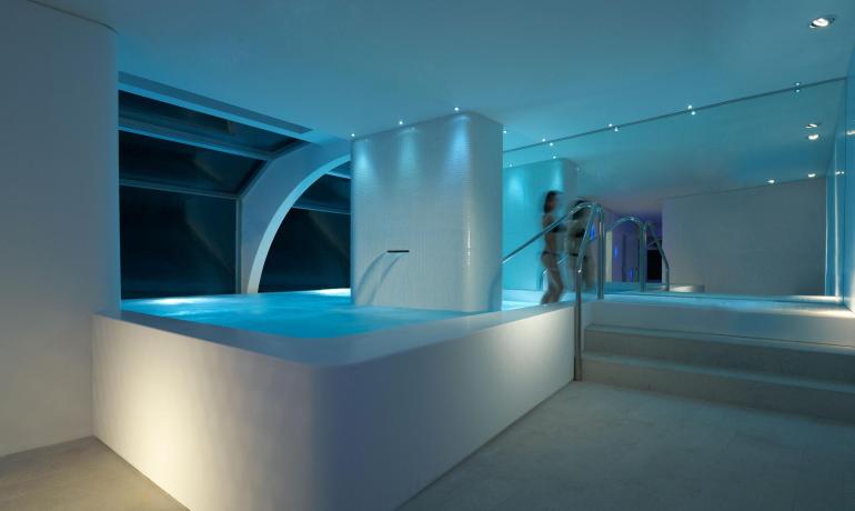 Piscine intérieure moderne avec éclairage doux et design élégant.