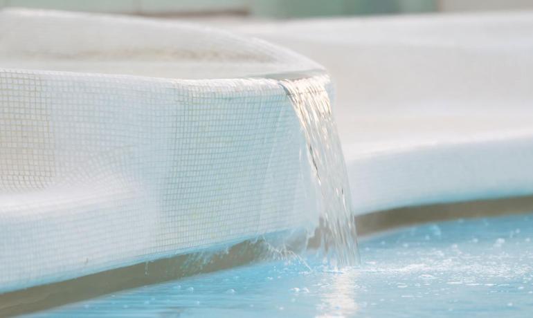 Pool with water cascade in a modern setting.