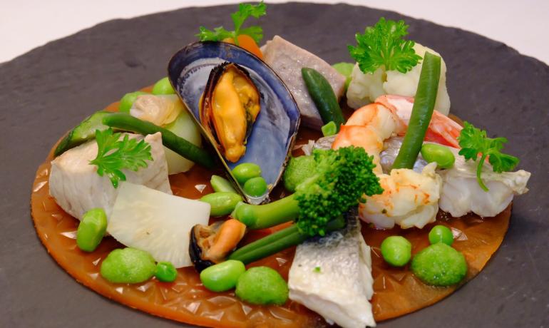 Plat gourmet avec fruits de mer et légumes.