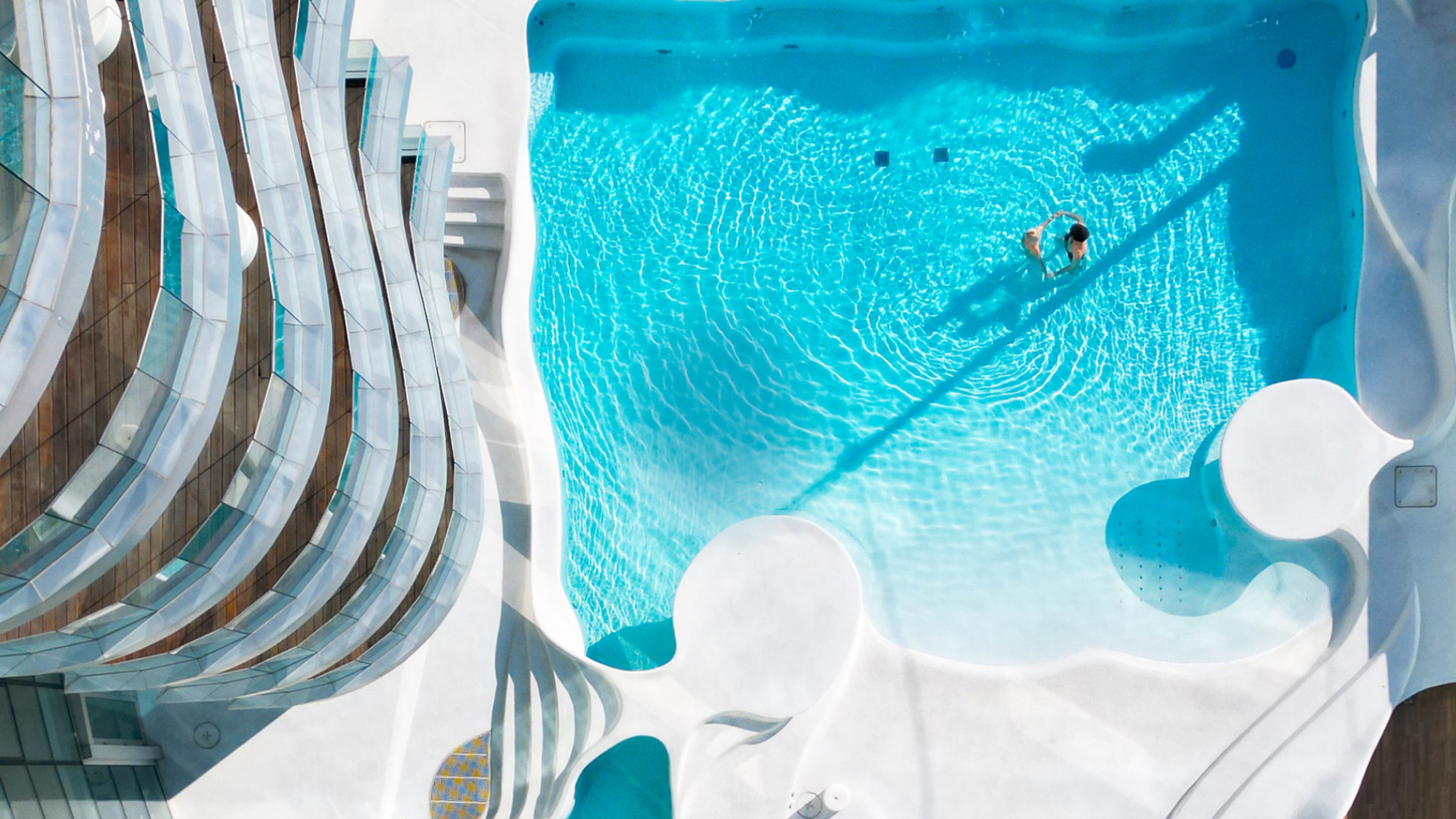 Vista dall'alto di una piscina con design moderno e linee curve.