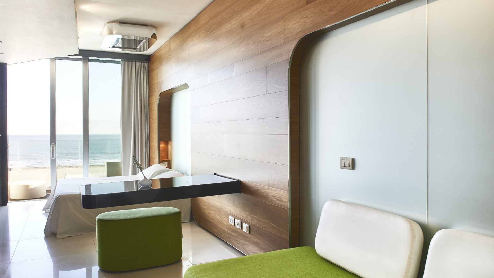 Camera moderna con vista mare, arredamento minimalista e dettagli in legno.