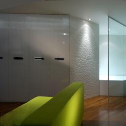Modern interior with soft lighting and green sofa, calm and futuristic atmosphere.