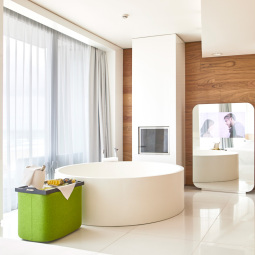 Bagno moderno con vasca rotonda, arredi minimalisti e dettagli in legno.
