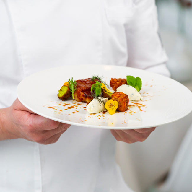 Elegantes Gourmetgericht mit Blumendekorationen und lebhaften Farben.
